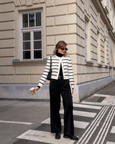 a lady wears a striped cardigan with black loose fit trousers